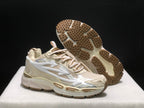 Angled view of the sneakers with one shoe lifted to reveal the brown textured outsole.