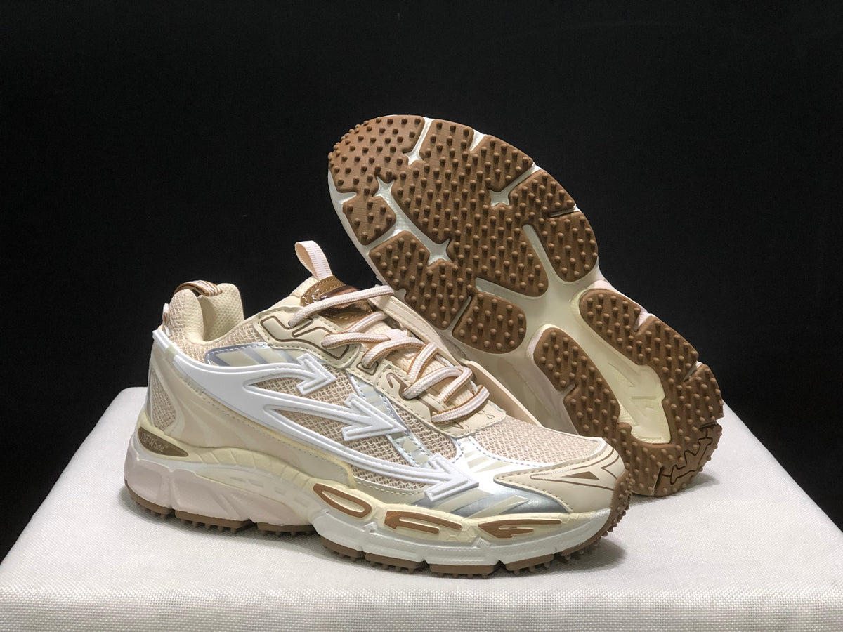 Angled view of the sneakers with one shoe lifted to reveal the brown textured outsole.