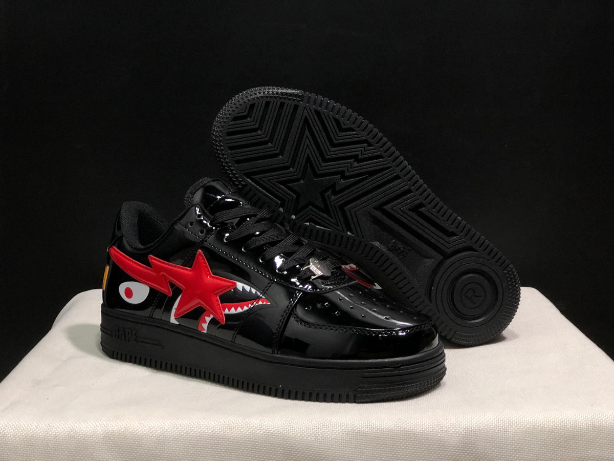 Angled view of the black sneakers with a lifted outsole showing a star-shaped tread pattern.