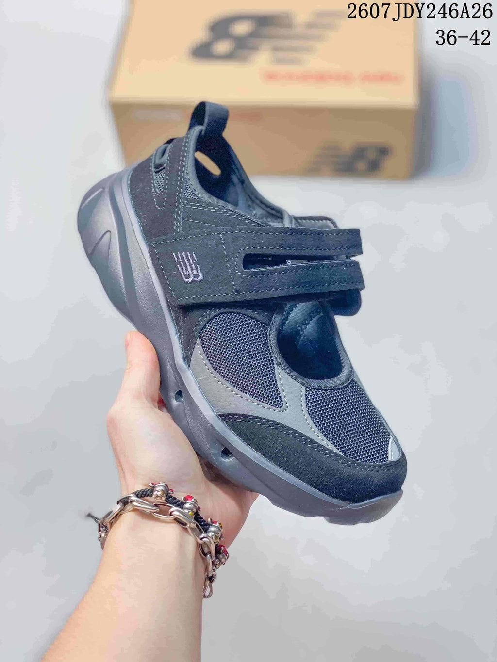 Three-quarter side view of the dark navy and gray sneaker with its layered upper and thick outsole.