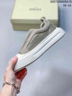 Side view of the taupe and white slip-on sneaker showing the textured side panel, stitching, and white platform sole.
