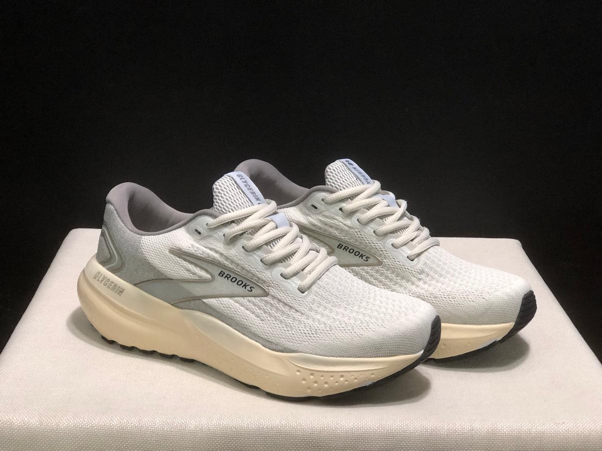 Three-quarter view of the white and light gray Brooks Glycerin 21 pair with cream-colored midsoles.