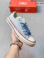 Angled side view of the light blue Converse All Star sneaker showing the lace-up upper, white rubber toe cap, and textured sole.