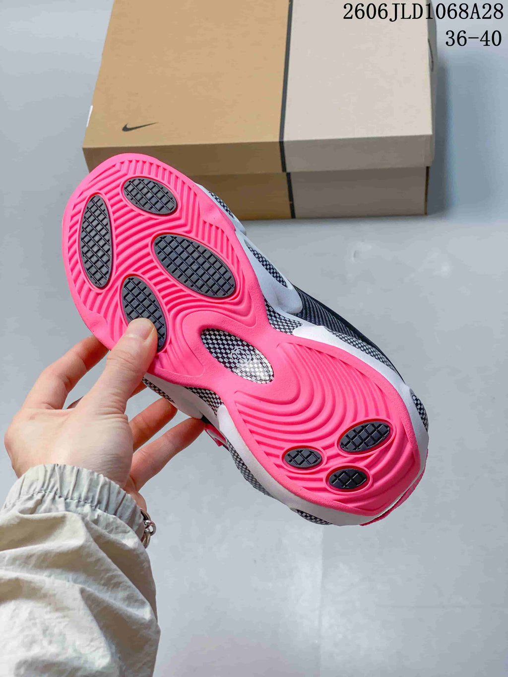 Underside of the sneaker showing a bright pink outsole with dark traction sections