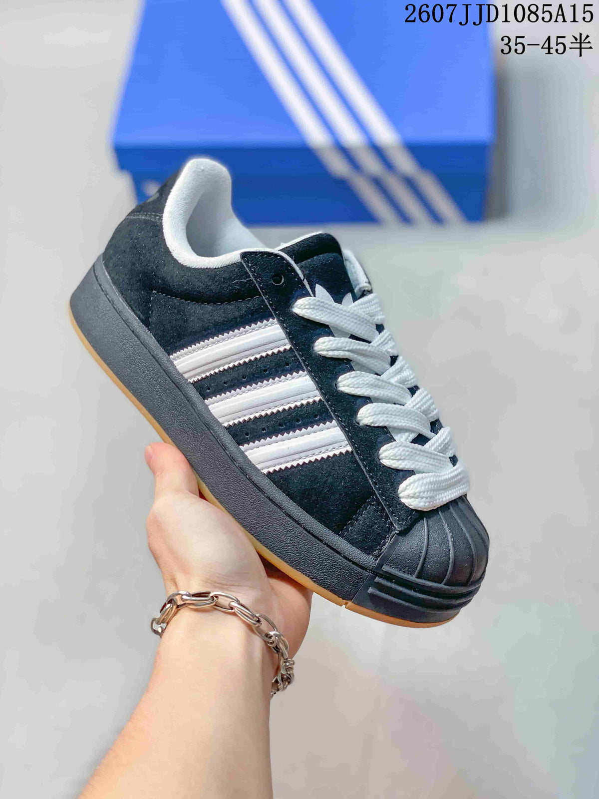 Side view of a black adidas shell-toe sneaker with white laces and white three-stripe detailing.