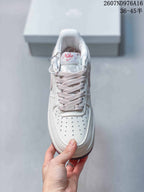 Top view showing the perforated toe box, pale pink laces and decorative lace charm.