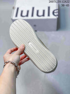 Underside of a sneaker showing a light-colored repeating textured outsole and lululemon branding.