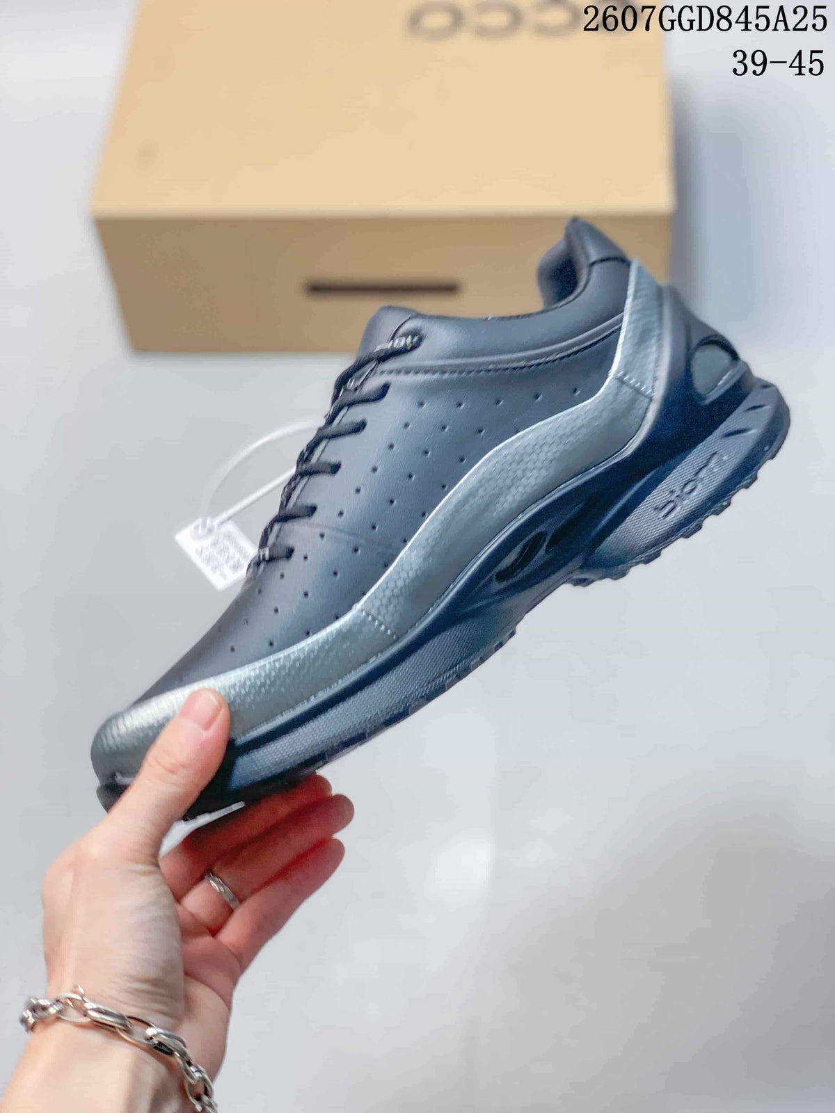Side profile of the black low-top sneaker showing the perforated upper, silver-toned overlay, lace-up closure, and treaded sole.