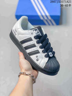 Angled side view showing the white and black color blocking, shell toe, three stripes, and side graphics.