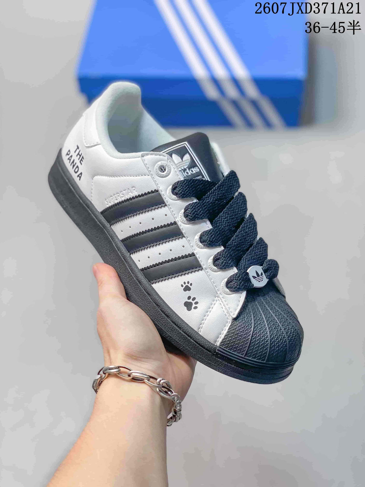 Angled side view showing the white and black color blocking, shell toe, three stripes, and side graphics.