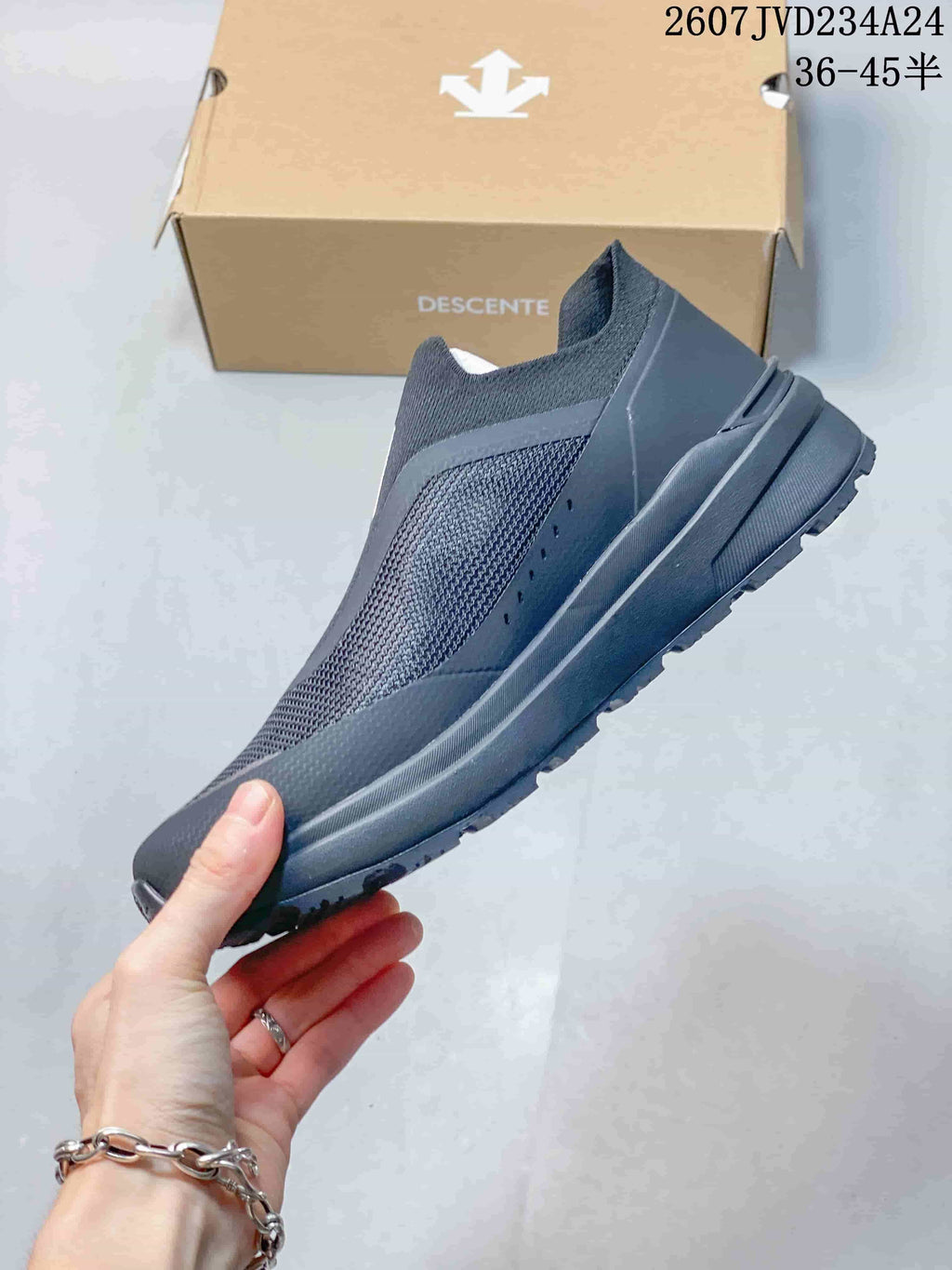 Side profile of the dark gray low-top slip-on sneaker showing its layered upper and sole design.