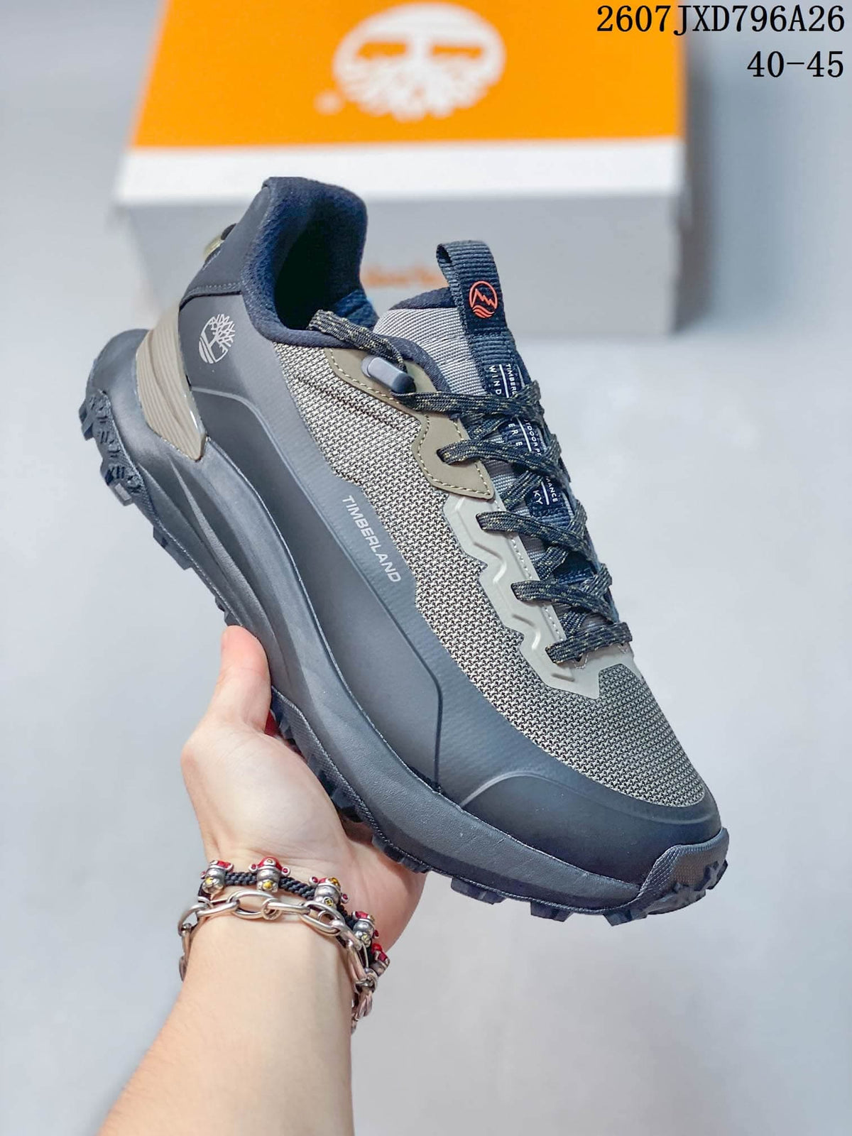 Angled side view showing Timberland branding, gray and navy color blocking, and the rugged sole.