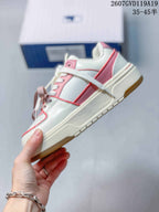 Side view of the low-top sneaker showing white and pink panels, layered trim, a raised midsole and gum-colored outsole.