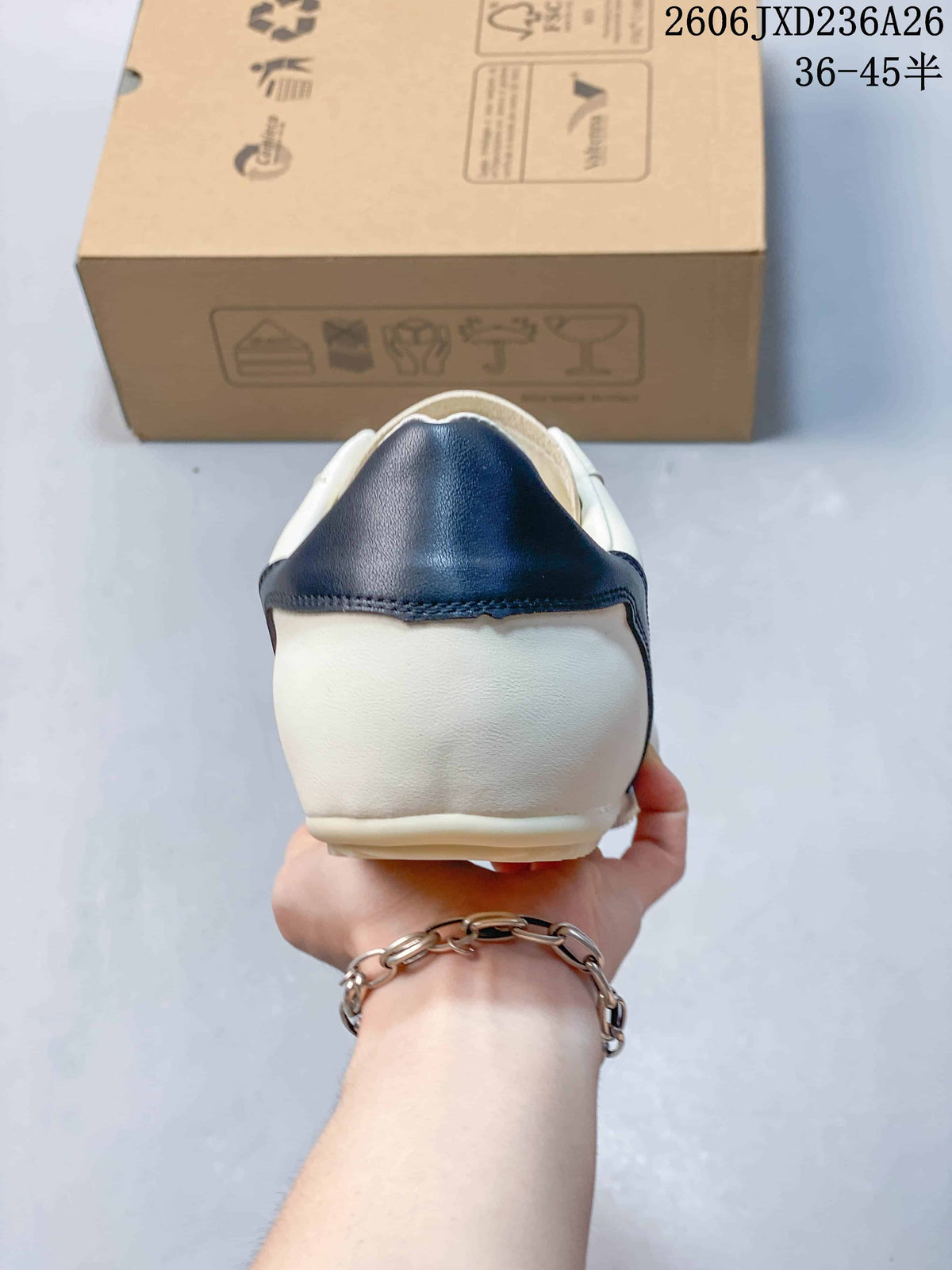 Rear view showing the navy heel panel on the white sneaker.