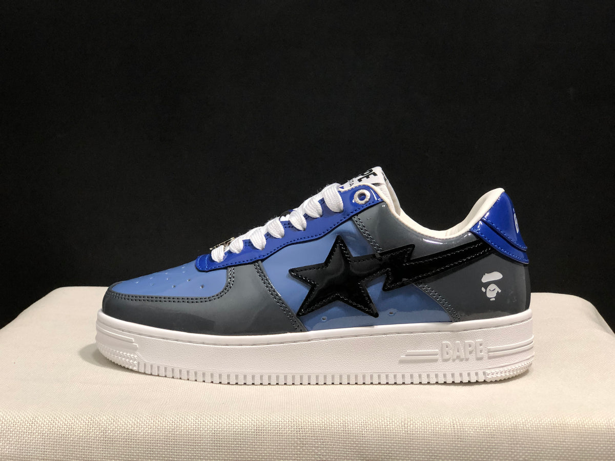 Side view of one blue and gray low-top sneaker with a black star detail and white outsole.