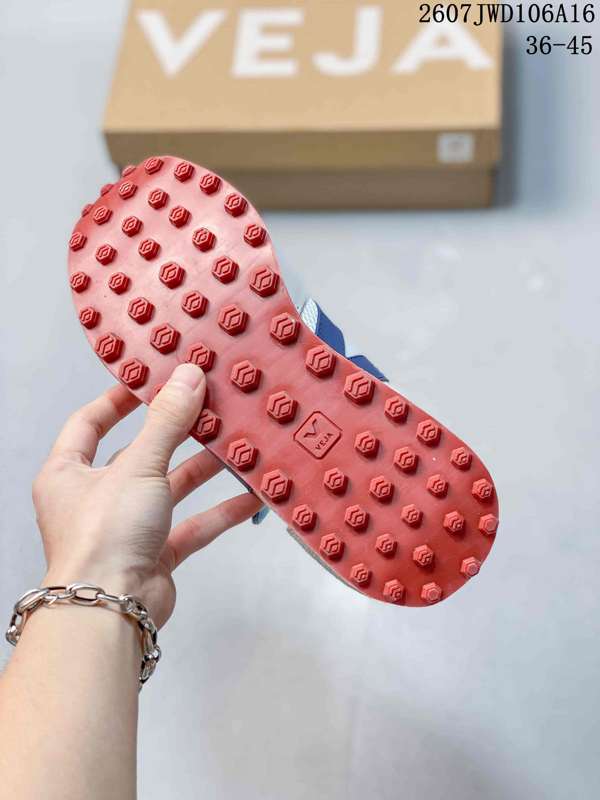 Close-up of the red textured outsole with raised geometric tread elements and VEJA branding.