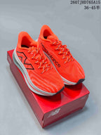 Pair of bright orange New Balance RC Elite running shoes displayed on a red shoebox.