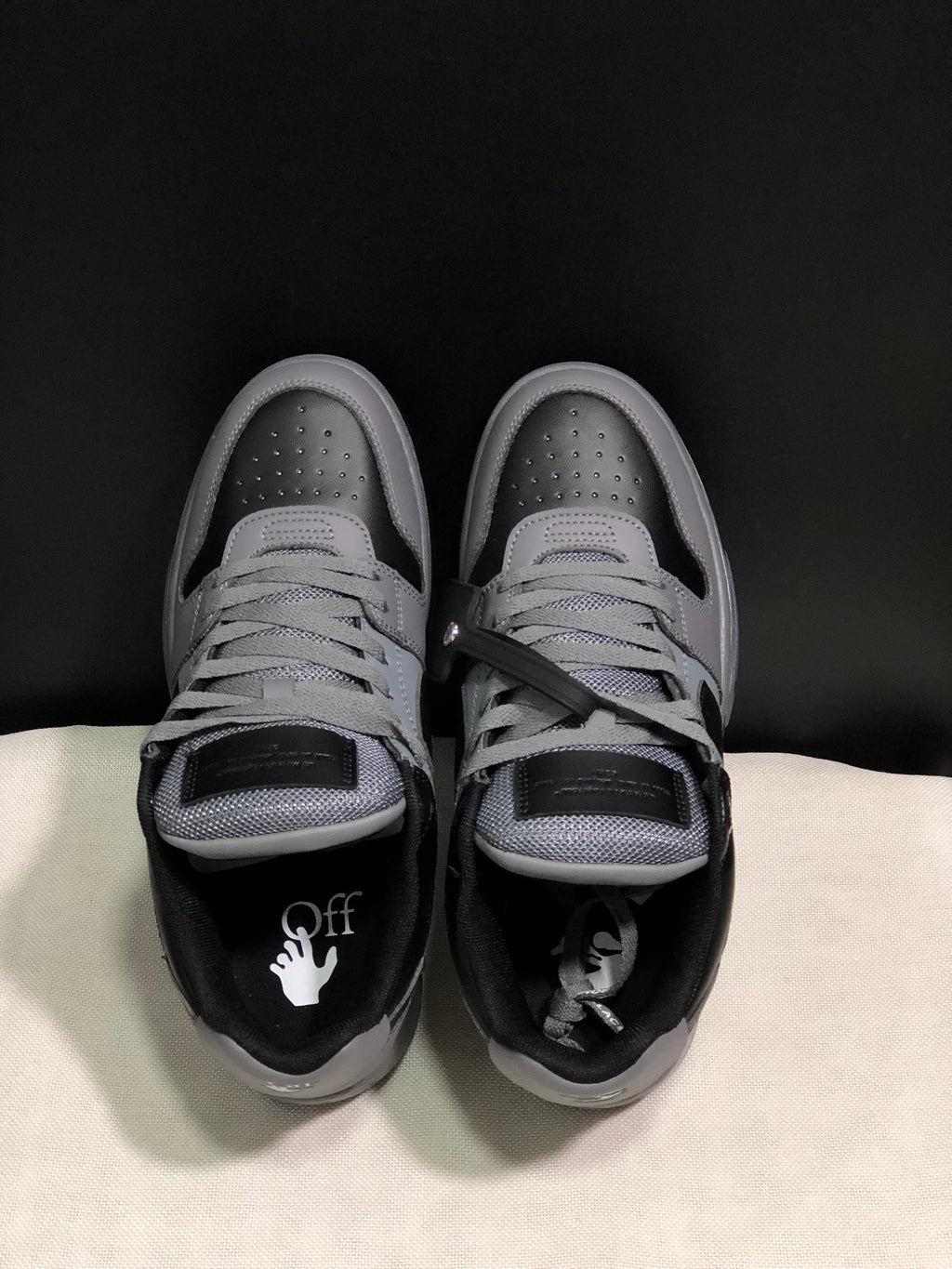 Top view showing the grey laces, padded tongues, perforated toe boxes and branded insoles.