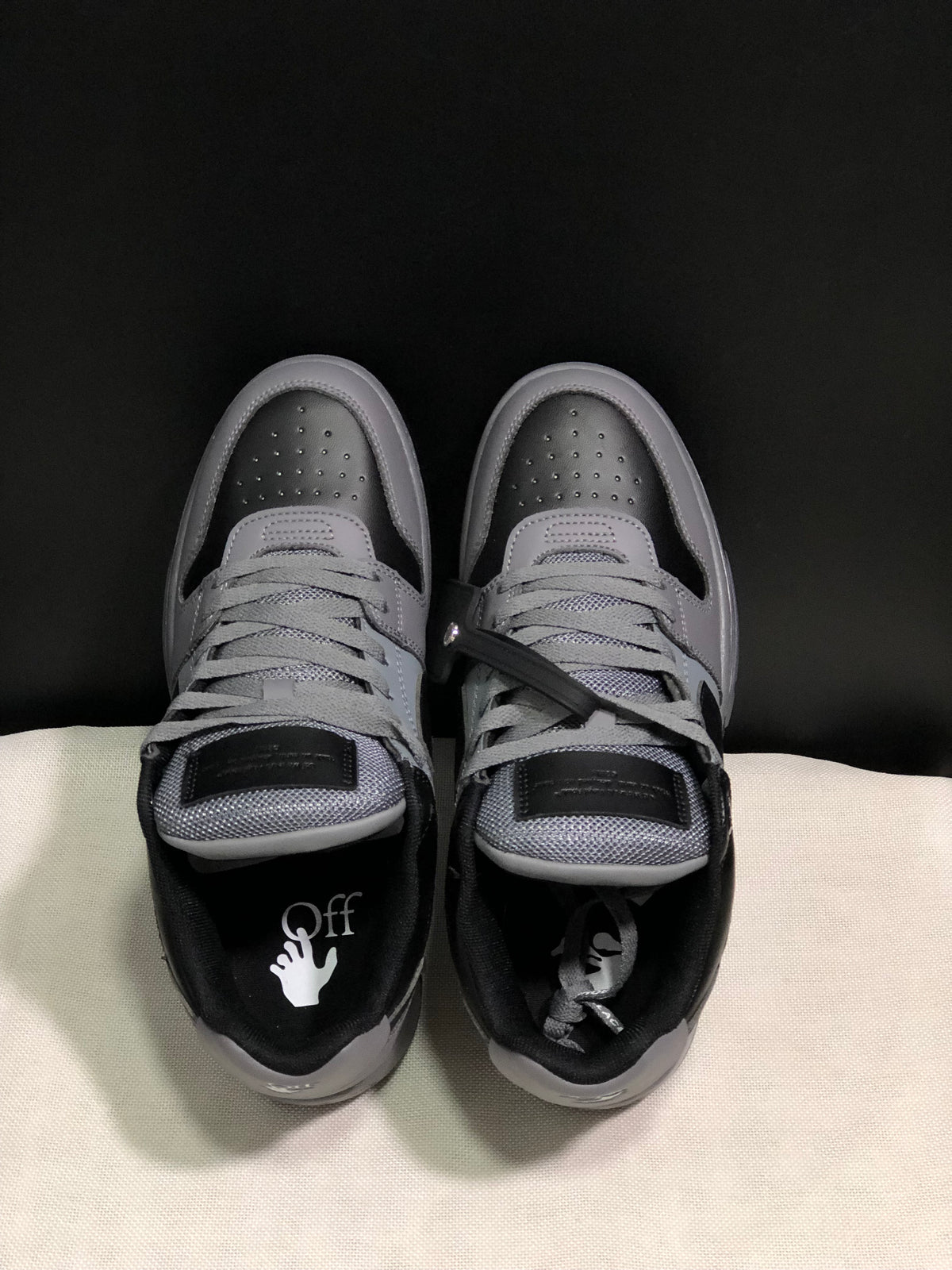 Top view showing the grey laces, padded tongues, perforated toe boxes and branded insoles.