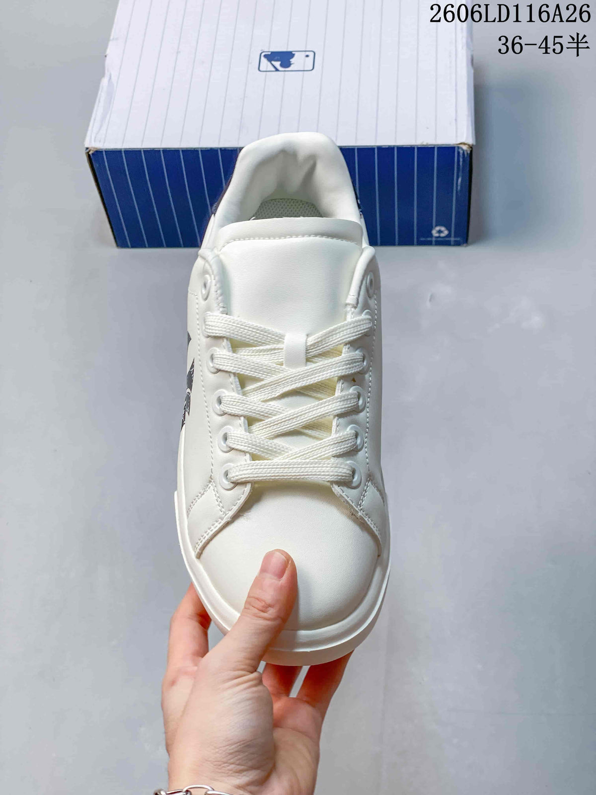 Top view of the white lace-up sneaker showing the rounded toe, tongue, and layered eyelet panels.