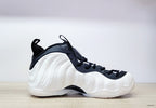 Side view of a white Nike Air Foamposite One high-top with black laces and collar