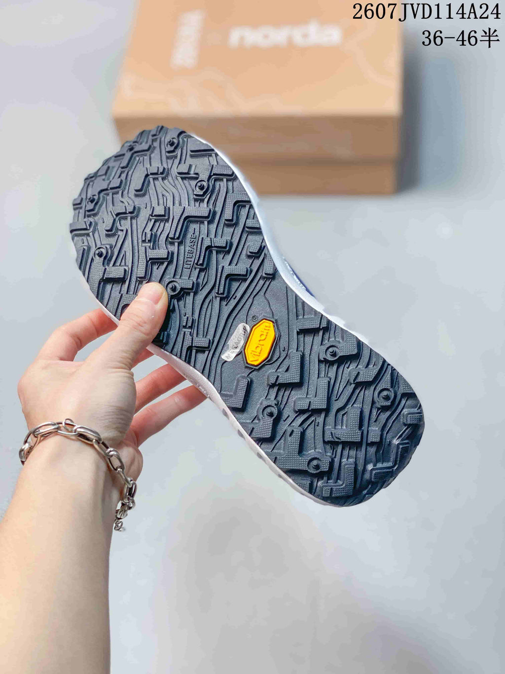 Close view of the black lugged outsole showing Vibram branding and textured tread.