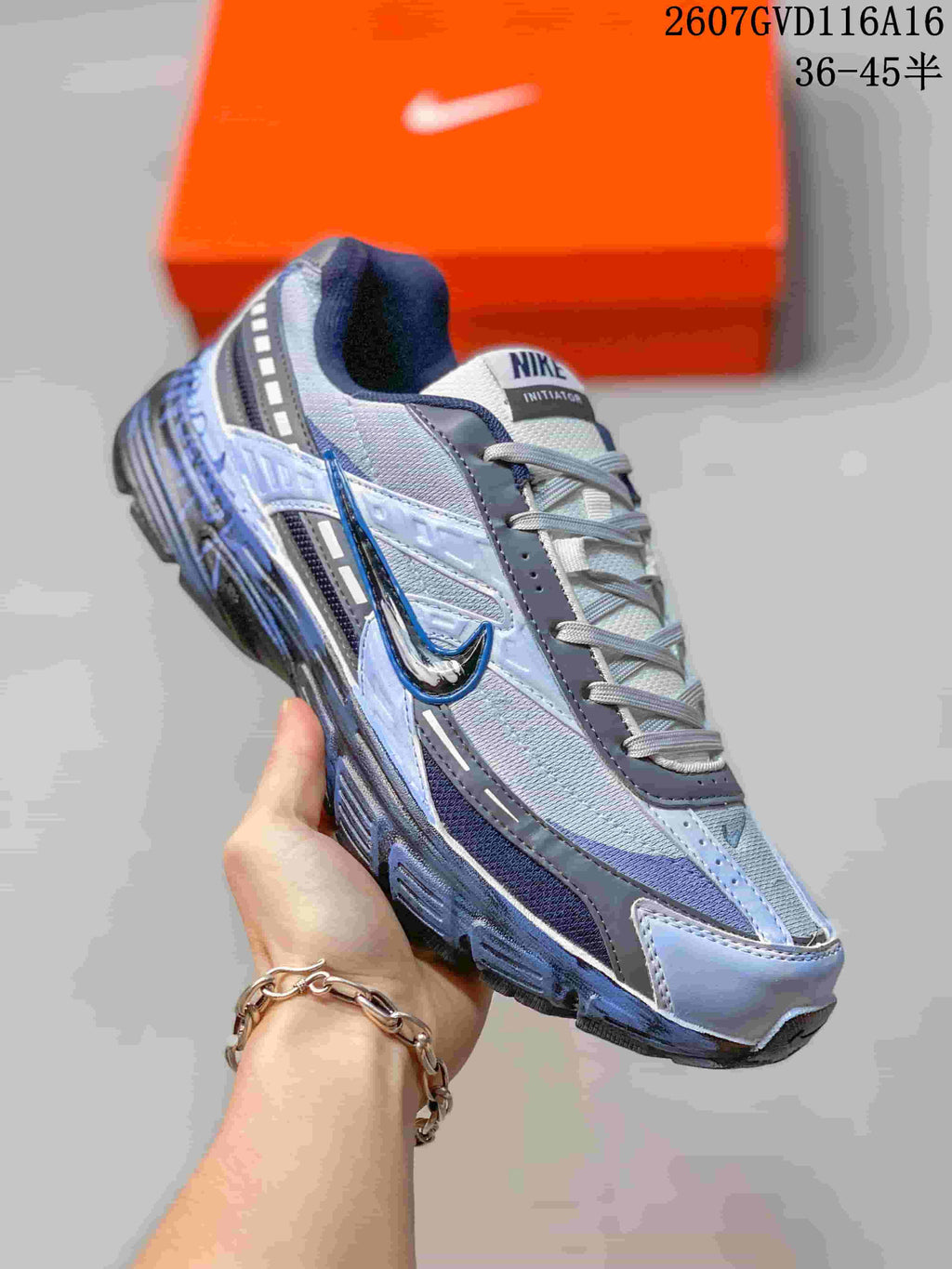 Angled side view of the blue-gray Nike Initiator sneaker with layered upper panels.