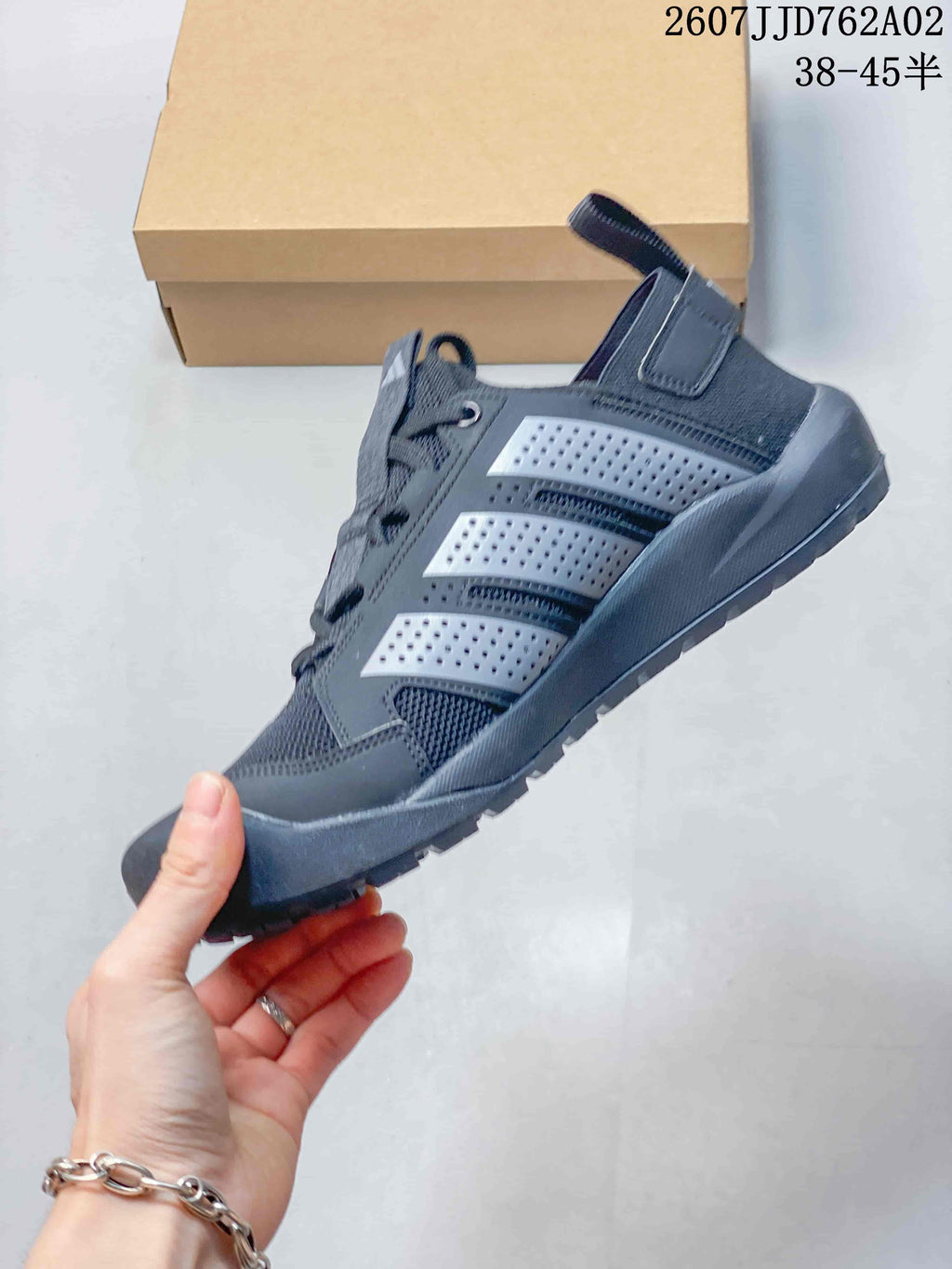 Side view of a charcoal grey outdoor shoe with light grey side details and a heel pull tab.