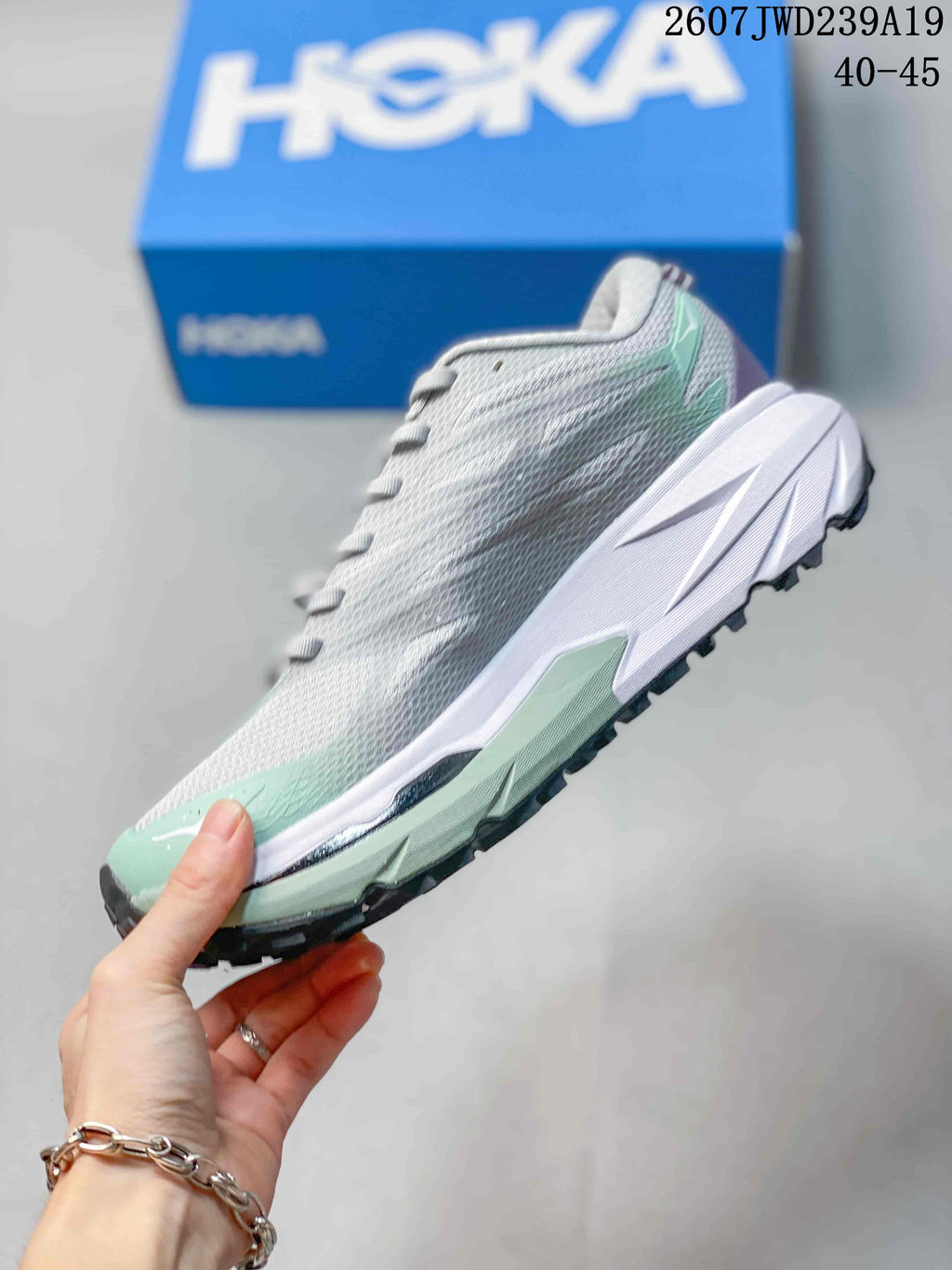 Side profile of the gray and mint low-top running shoe with a white midsole and textured upper.