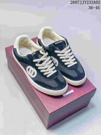 Pair of blue Gucci G75 low-top sneakers with white laces, circular side emblems and white soles.