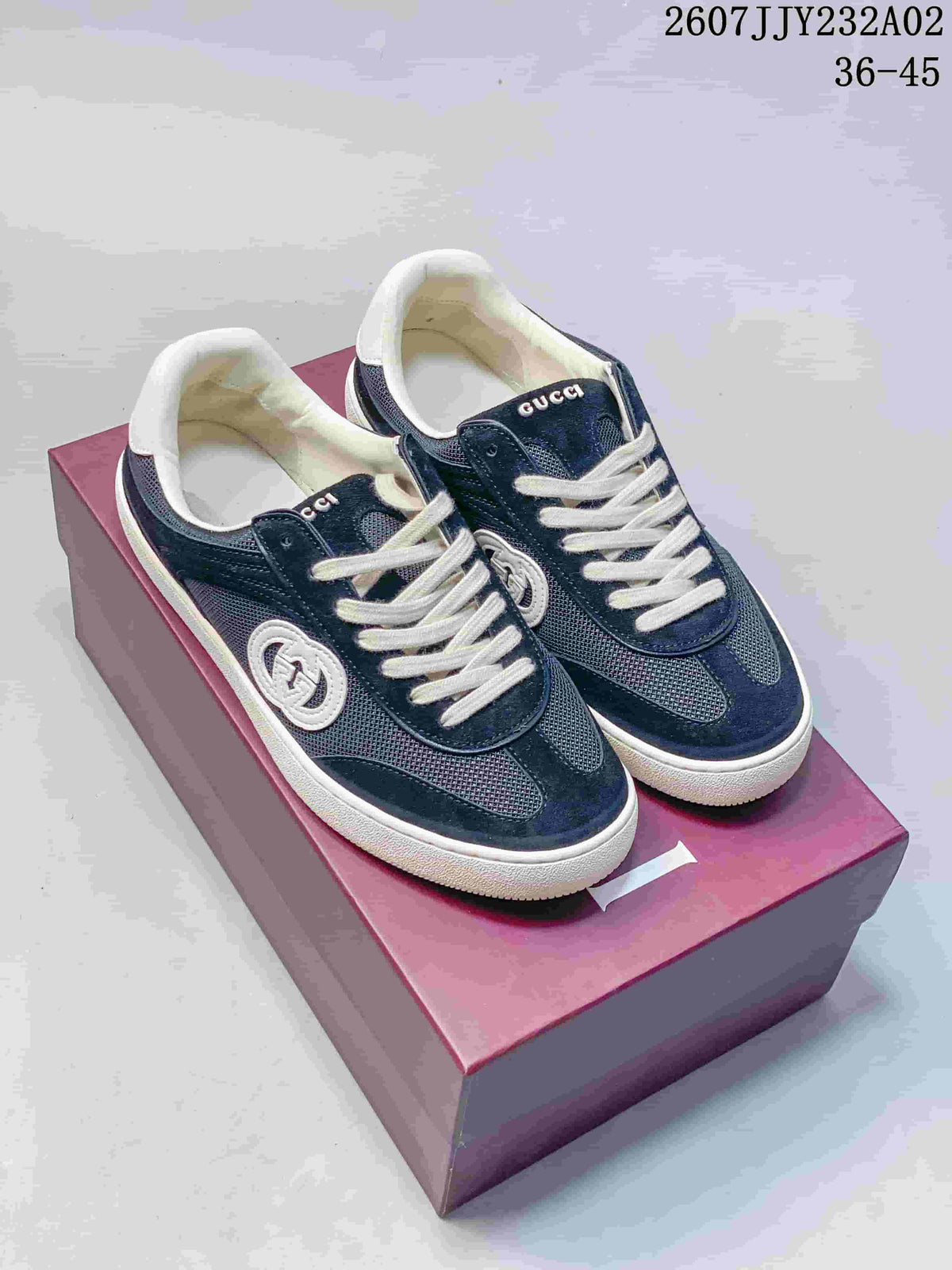 Pair of blue Gucci G75 low-top sneakers with white laces, circular side emblems and white soles.