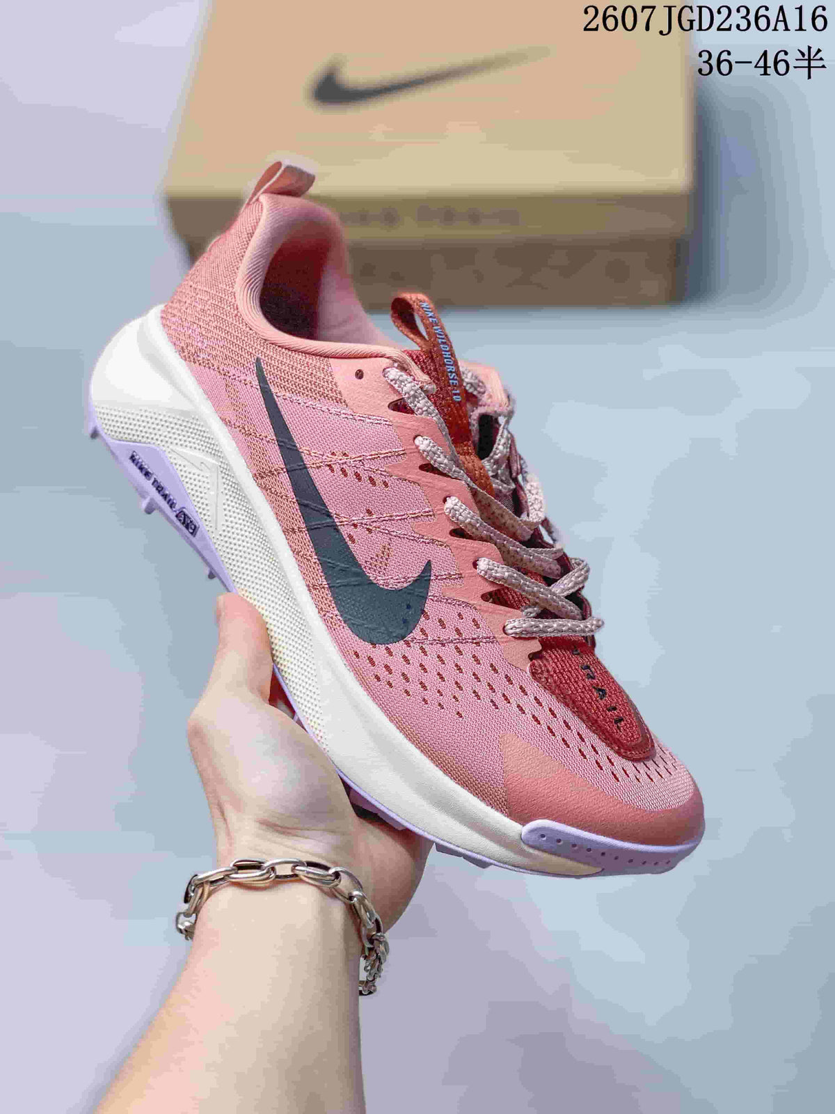 Angled side view showing the pink upper, dark Nike Swoosh, white midsole and lavender outsole details.