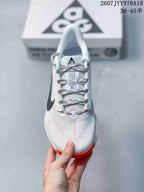 Top view of a Nike ACG Pegasus Trail shoe showing the patterned laces, tongue branding, and textured light-colored upper.