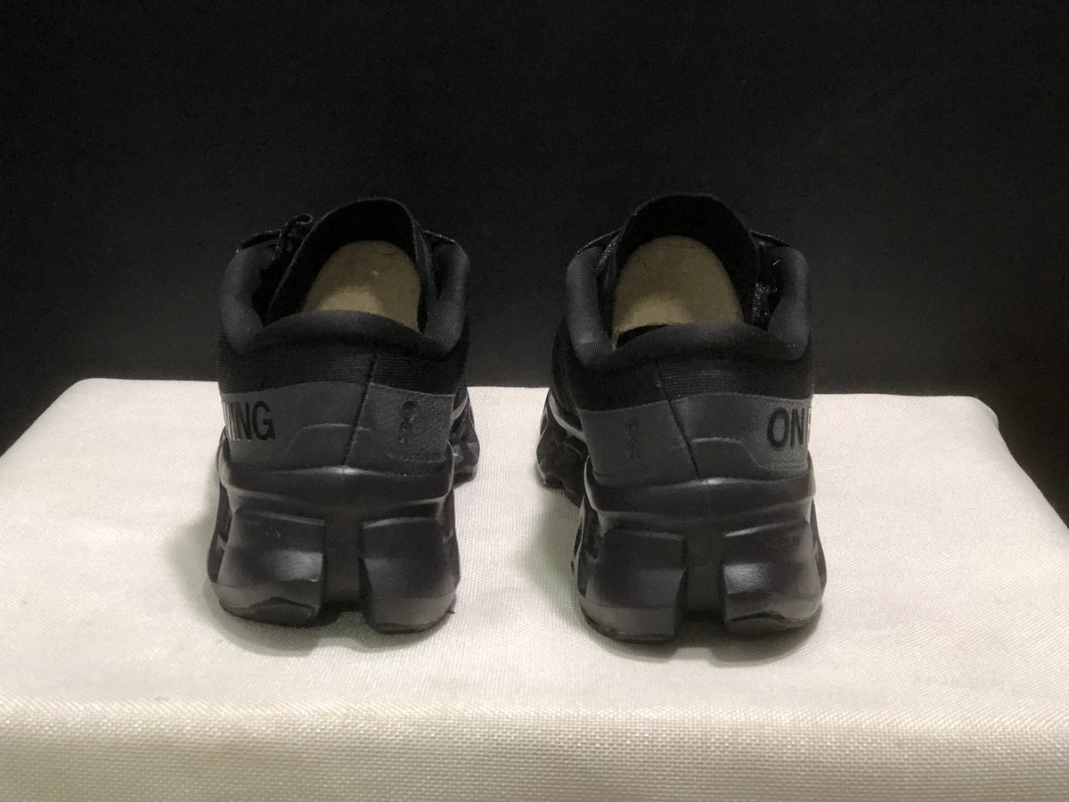 Rear view showing the padded heels, branding and segmented black outsoles.