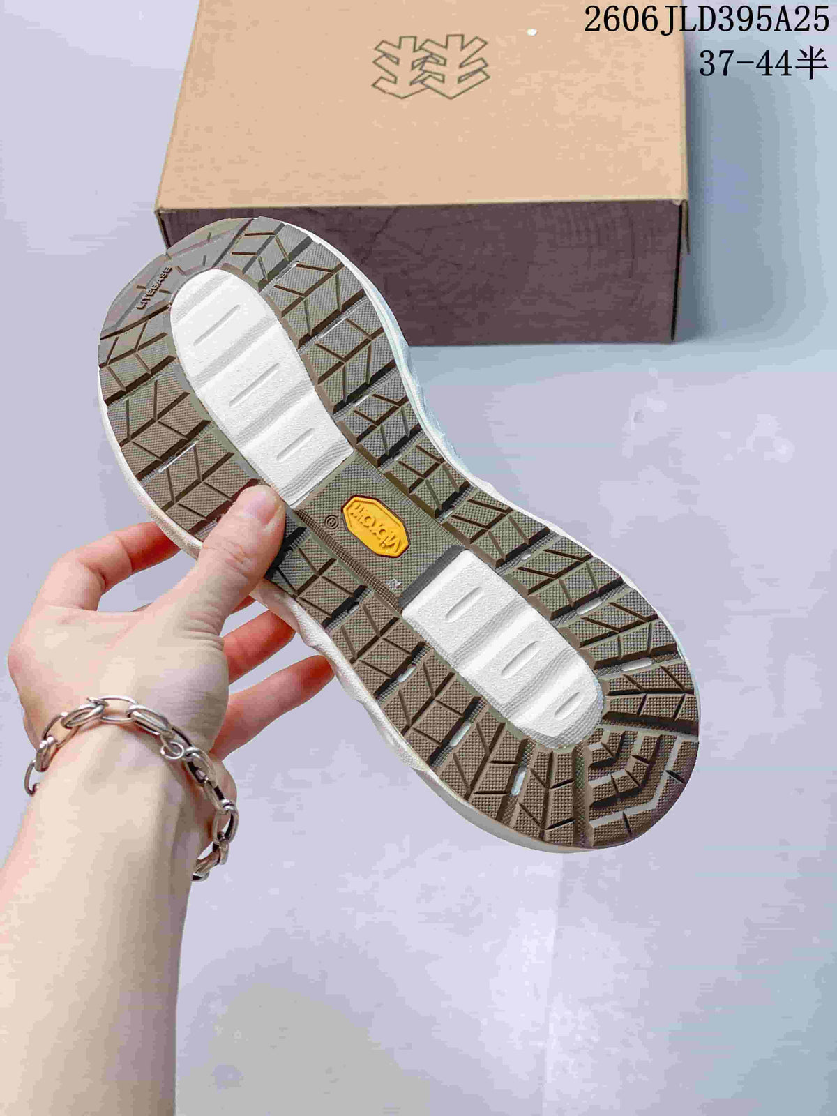 Underside of a shoe showing patterned tread and a central logo detail.
