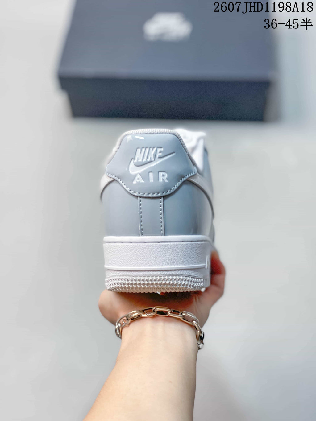 Rear view of a gray and white low-top sneaker showing the Nike Air heel branding.