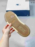 Underside of the sneaker showing a cream and gum-colored outsole with a repeating herringbone tread pattern.