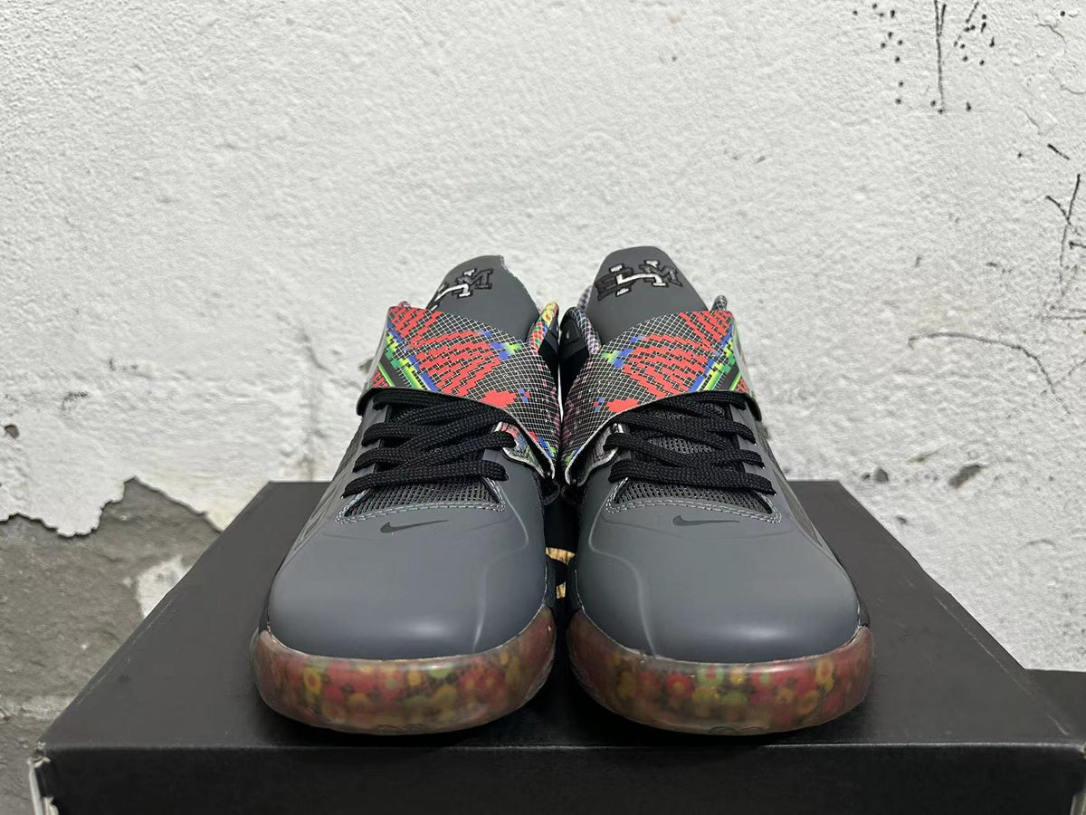 Front view of charcoal basketball shoes with black laces, colorful geometric straps, and translucent-looking outsoles.