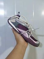 Close-up angled view of a purple and pink Skechers 5159 sneaker with mesh panels, layered side details, cream laces, and a textured outsole.