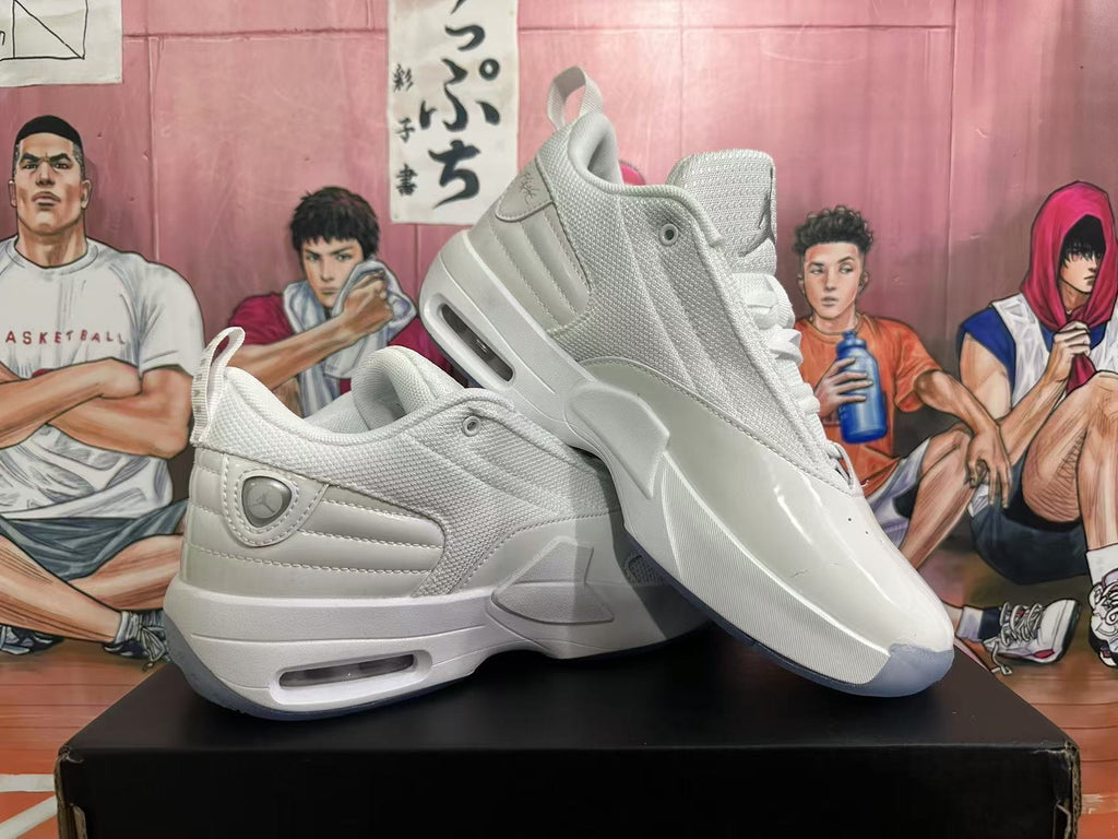 Angled view of a pair of white Jordan sneakers showing the side panels, lace-up construction, heel air windows, and gray outsole accents.