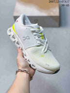 Angled side view of the white and lime On Running sneaker showing the upper, heel accent, laces, and outsole structure.