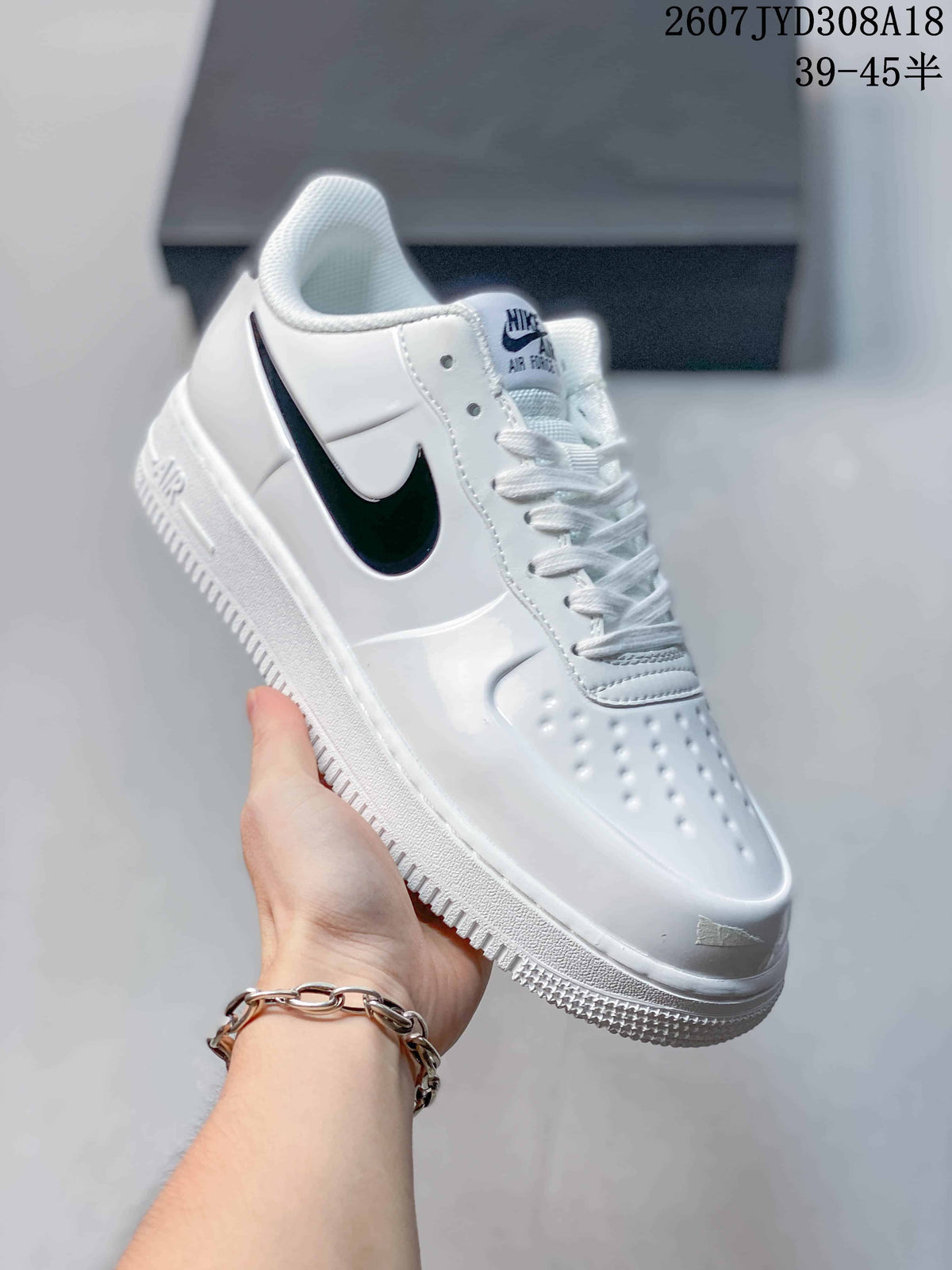 Angled side view of the white low-top sneaker with black Swoosh accents and layered sole.