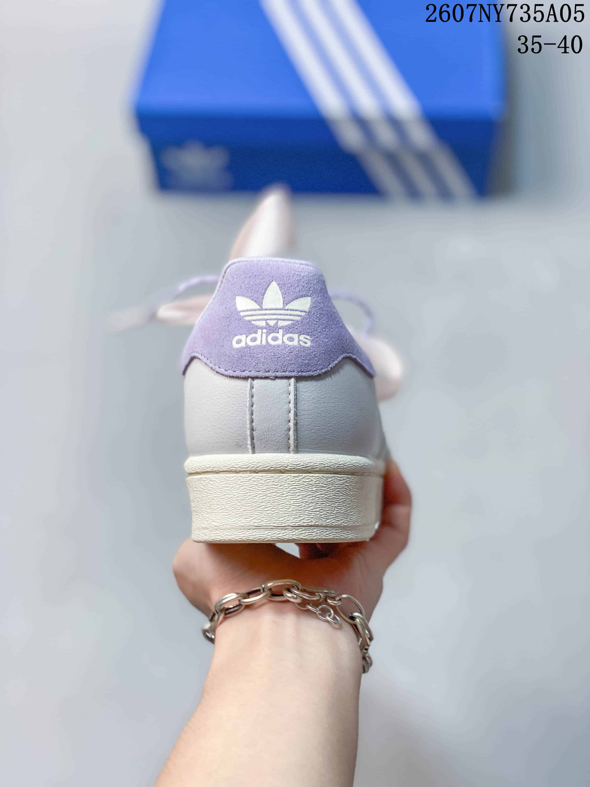 Rear view showing the lilac heel tab, Adidas Trefoil branding, and white rubber heel.