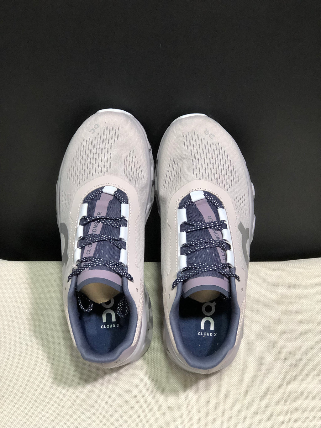 Top view of the On Cloud X sneakers with patterned laces and branded insoles