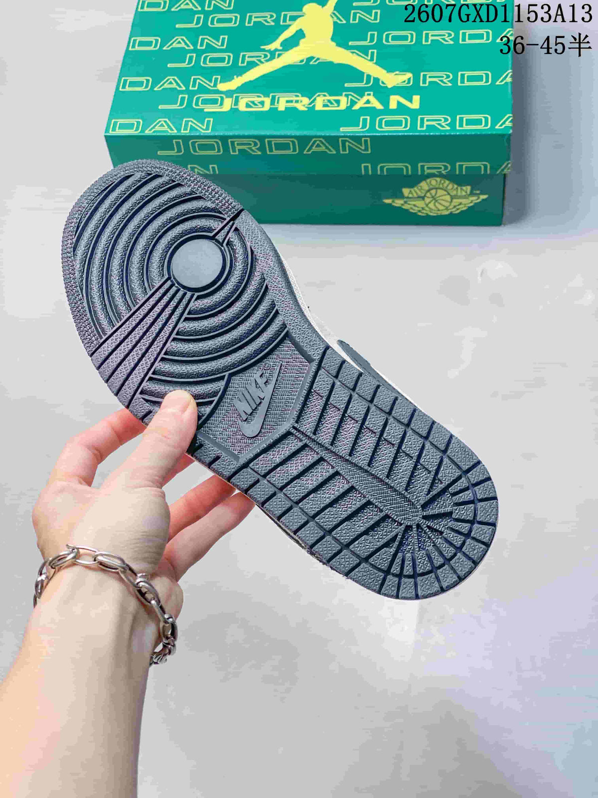 Close view of the textured outsole showing circular forefoot traction and rectangular tread sections.
