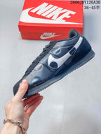 Side profile of a dark Nike Classic Cortez sneaker with silver side detailing