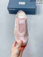 Top view of a pink closed-toe slip-on showing its openwork upper and cream-colored side stripes.