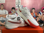 Angled view of white Nike GT Cut 3 basketball shoes showing red outsole details and side branding.