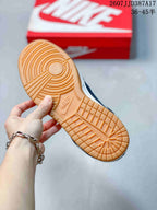 Close-up of the gum-colored outsole with circular and grid traction patterns and a molded Nike Swoosh mark.