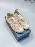 Pair of cream-toned Onitsuka Tiger MEXICO 66 sneakers displayed on a shoebox, showing the textile upper, laces, and low-top profile.